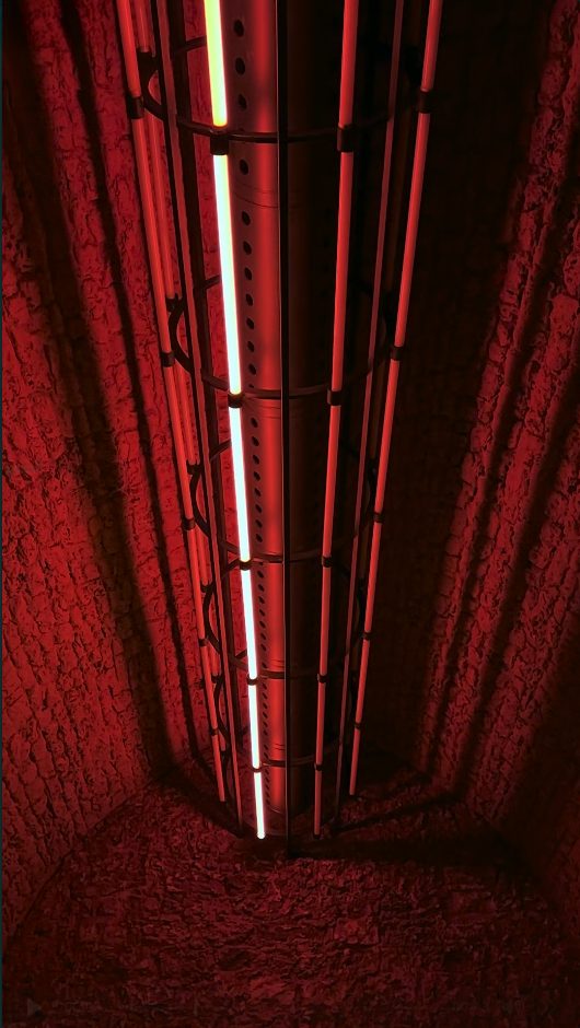Cage fixture glowing down the corridor