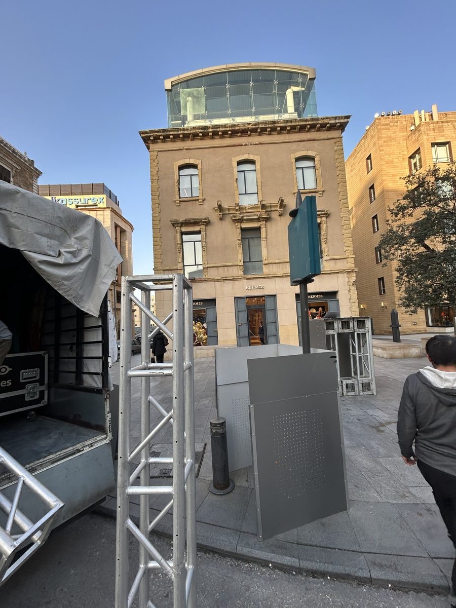 Daytime rigging and projector setup on the square